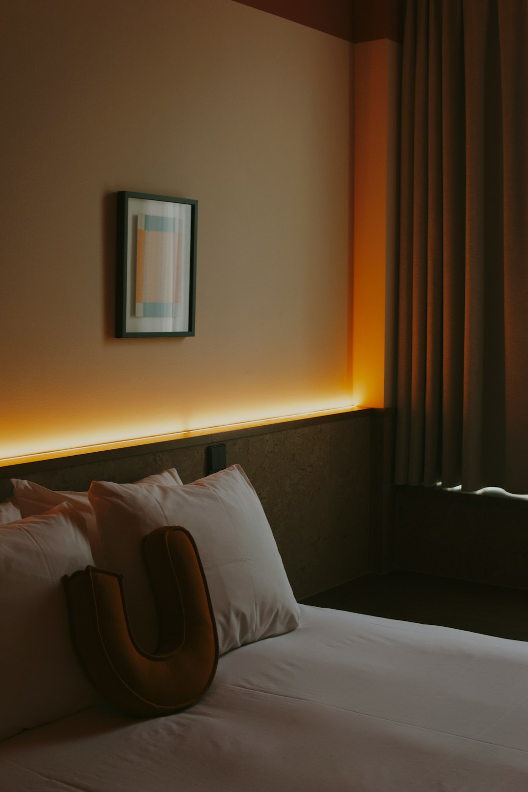 a-hotel-bed-with-pillows-and-ambient-lighting-tgl92jl9kni