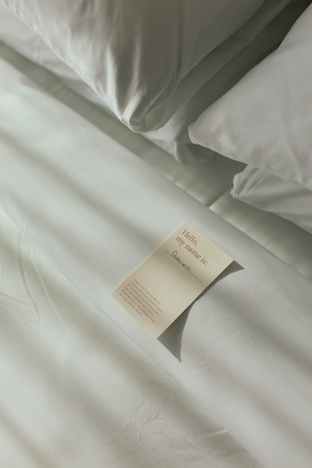 a-sheet-of-paper-on-a-bed-with-white-sheets-xee-kdcsu3c